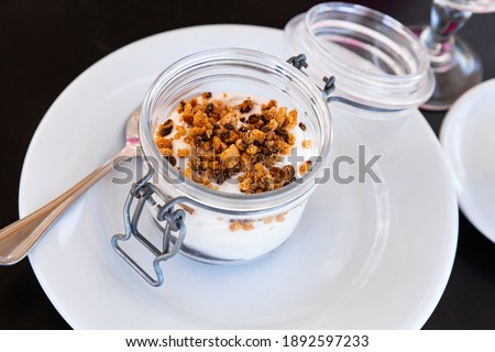 Tiramisu traditional italian dessert in glass jar, garnished with cookies