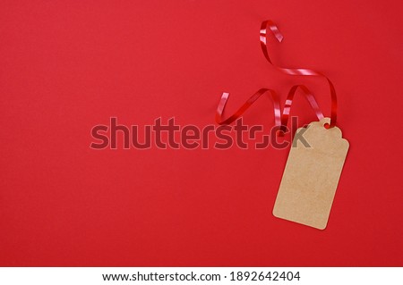 Carton tag for gift box with space for text on red background. Top view. High quality photo