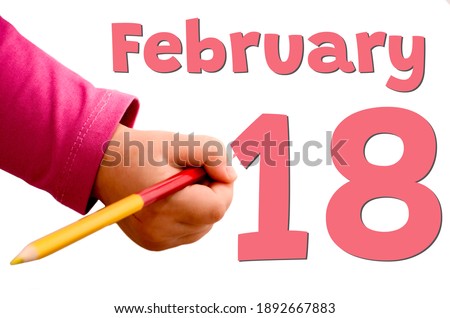 Children's hand writes February 18 in red pencil. White background with winter date, business and holiday concept.