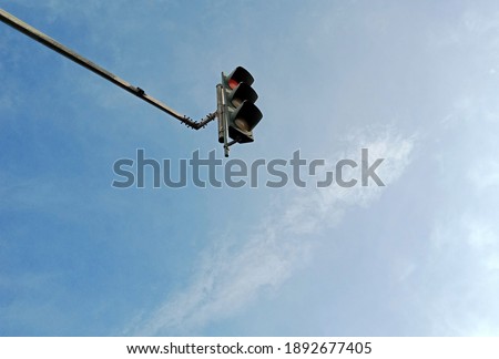 looking up to a high mount traffic light on a clear blue sky day