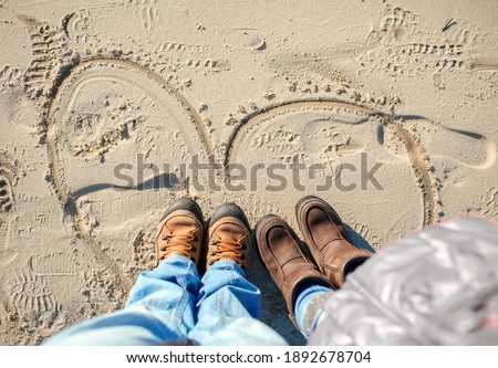 Family enjoying winter together, kids with parents walking on the beach in winter, cold temperature and sunny day, love keep you warm, happy real people. Outdoors lifestyle