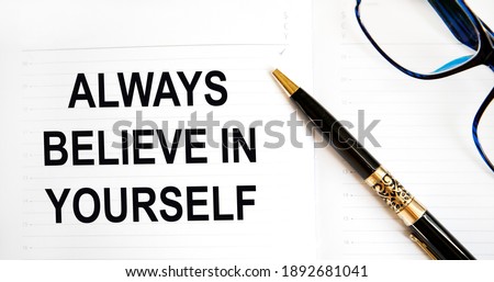 In the diary the text always believe in yourself, next to the pen and glasses.