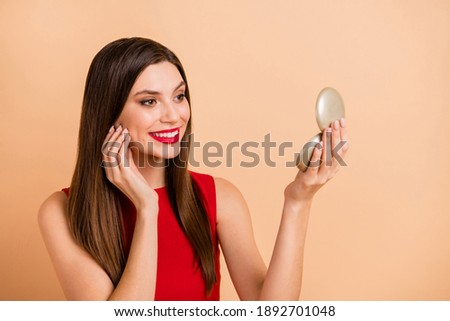 Profile side photo of pretty positive young lady hold pocket mirror touch face skin isolated on pastel beige color background