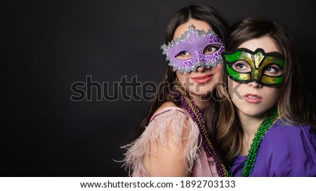 Mardi gras people. Women with a carnival mask and beads on the black background with copy space.