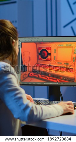 Woman game sotware developer testing new game overtime at night in start up creative agency company. Tired worker developing new online video games on pc with modern technology