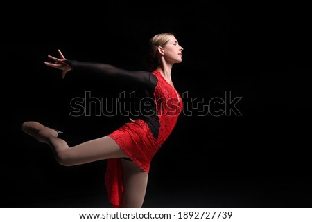young woman figure skater on a dark background