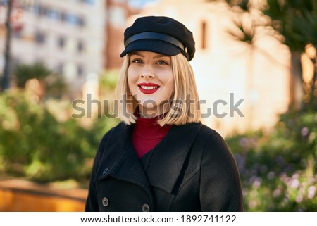 Young blonde woman smiling happy standing at the city.