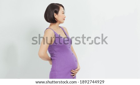 Young smiling beautiful pregnant woman in dress