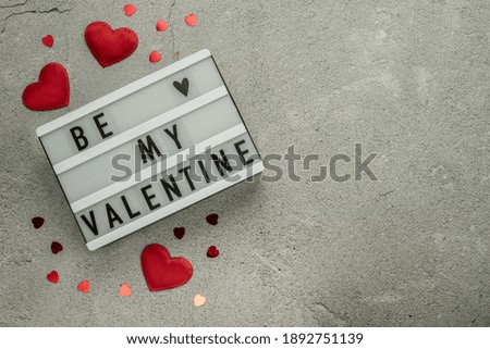 Be my Valentine with red heart shaped glitter on gray cement background with copy space, Valentine's day layout