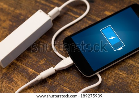 Phone charging with energy bank. Depth of field on Power bank Royalty-Free Stock Photo #189275939