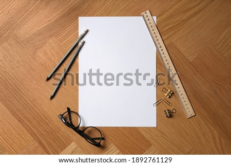 Flat lay composition with sheet of blank paper on wooden background. Space for text