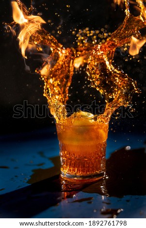 Special effect refection with water and fire in glasses on ground with black background.