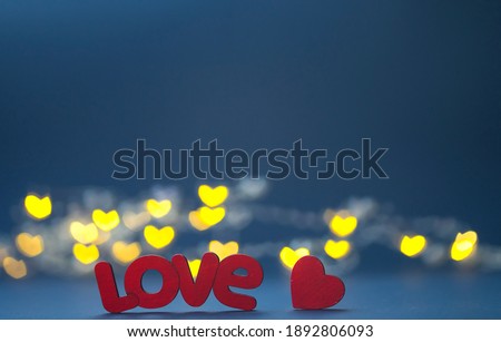 Composition for valentine's day or wedding. The inscription "Love" on a dark background. Heart Shaped Lights