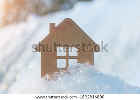 small wooden house close-up in winter, on a background of snow. Idea - winter discounts for home purchases, 2021 sales, New Year discounts. affordable housing, mortgage. Horizontal photo Royalty-Free Stock Photo #1892816800