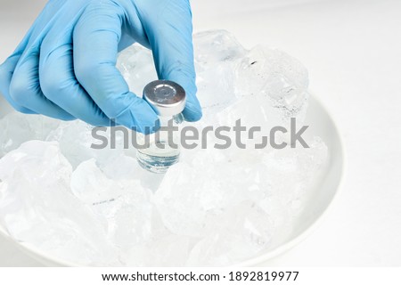 A doctor taking a vaccine vial from cold refrigerator and prepare injection. Vials on the ice. Long-term storage of Covid-19 vaccine. Coronavirus vaccine vials kept in cold storage temperature Royalty-Free Stock Photo #1892819977