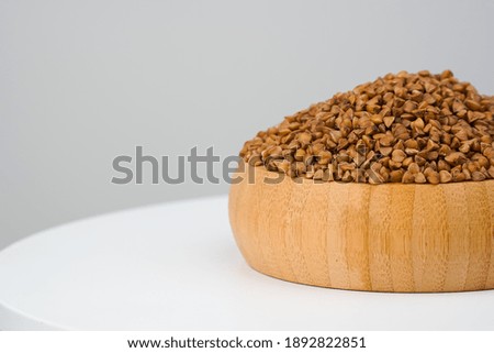 Dry, raw buckwheat grains on white background․ Copy space.