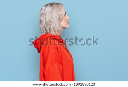 Young blonde girl wearing casual clothes looking to side, relax profile pose with natural face with confident smile. 