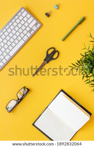 Flat lay office workspace with keyboard and office supplies, top view