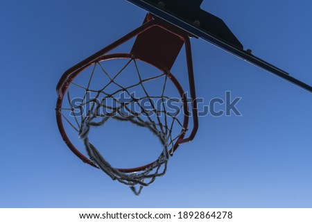 A low angle closeup shot of a basketball hoop with a net
