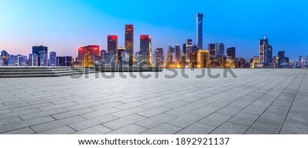 Empty square floor and modern city commercial buildings in Beijing at night,China.