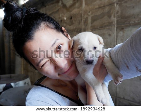 Asian woman smiling selfie with puppy