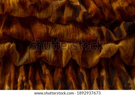 Silk fabric made of fine organza with print imitating panther skin, brown. Texture. Background. Template.