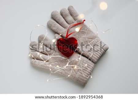Valentine's Day photo with glass heart and garland lights on white background. Flat lay photography