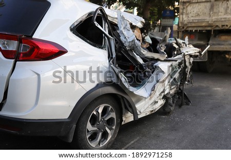 Closeup of right side of damaged smashed white sedan car from road traffic accident. The image for road traffic accident reduction campaign and  insurance business. Royalty-Free Stock Photo #1892971258