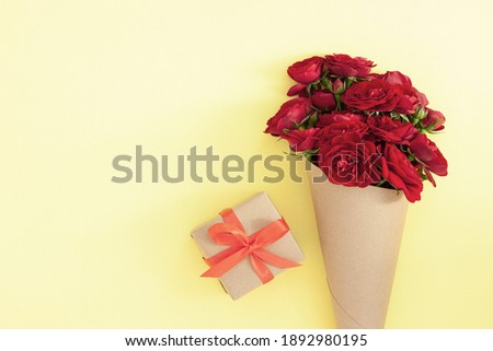 Red rose bouquet wrapped vintage craft paper. Greeting card for holiday text. Top view, flat lay