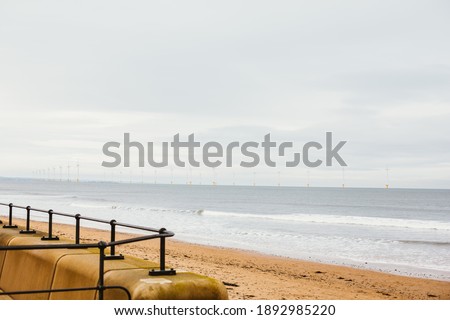 sea embankment with view to wind turbines. horizontal photo