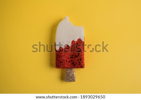 Christmas tree toy in the form of popsicle ice cream on yellow background