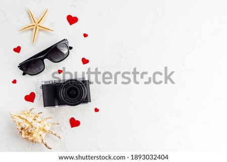 Vintage camera with sunglasses and shells. Travel concept.