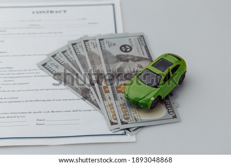 Toy car and contract on a white table. Car purcase and insurance concept