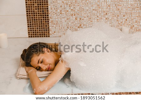 Luxurious relaxing foam massage in the Turkish hammam. Masseur crumples woman's skin in hammam.