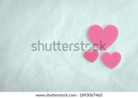Three pink hearts on white sheet resemble as love and family in Valentine.
