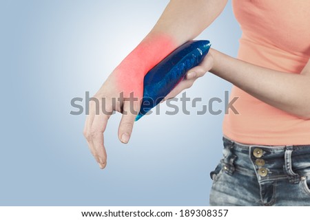 Cool gel pack on a swollen hurting wrist. Medical concept photo. 