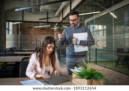 Businessman firing his crying secretary. Upset woman sitting at workplace, her angry boss point at door, copy space. Stress at work, emotional pressure, angry boss and unhappy employee Royalty-Free Stock Photo #1893112654