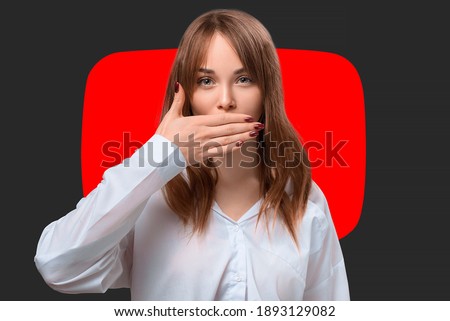 Young pretty girl protests against social media censorship. The woman covers her mouth with her hand for fear of censorship. Restrictions and taboo topics. Channel ban.  Royalty-Free Stock Photo #1893129082