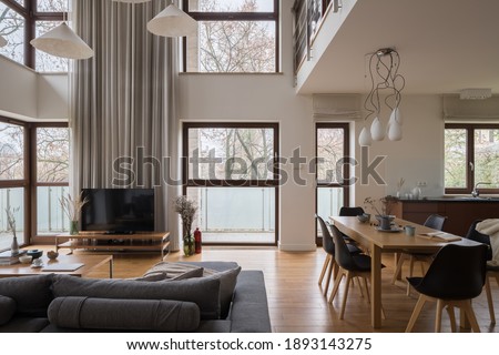 Stylish and luxury two-floor apartment with living room, dining room and kitchen in one room with amazing big windows Royalty-Free Stock Photo #1893143275