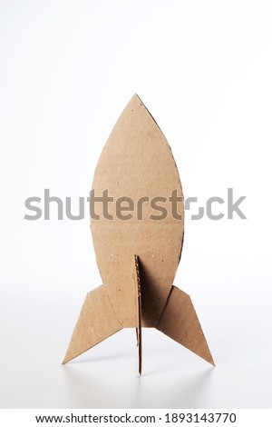 Rocket made of cardboard on a white background. Children art project. DIY concept. Cardboard craft.