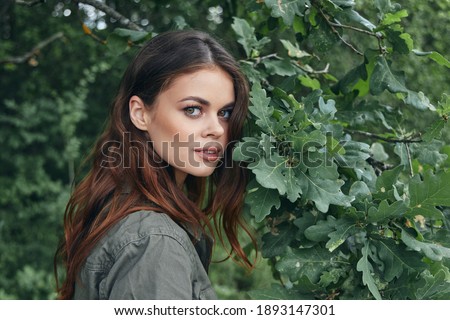 Woman outdoors Attractive look green leaves of trees summer 
