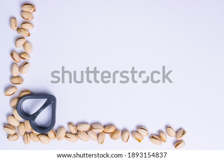 Pistachio frame and cookie cutter. Snack cooking concept on ultimate gray, advertising space.