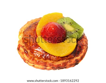 Croissant with strawberries, peach and kiwi on a white plate
