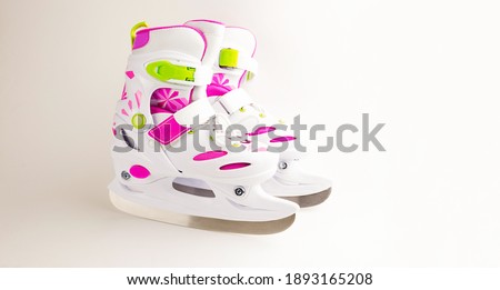 Children's ice skates with size adjustment-sliding with fixation. Plastic skates on a white background, copyspace