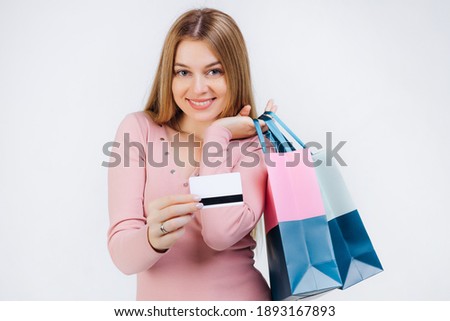 Close up shot of Asian woman carry colorful paper bags over the shoulder and holding credit card, concept for shopaholic girl, isolated on white background