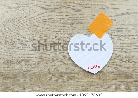 White paper heart shaped on the wooden floor and have copy space.