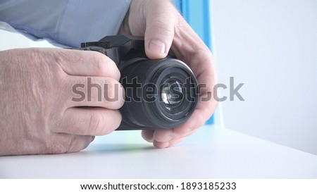 Photographer in a Photo Session Sets the Camera Focus for Taking a Picture