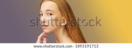 Cosmetology concept. Skin care product. Female portrait. Face mask. Home peeling. Grey background. Copyspace. Facial lifting treatment. Dermatology beauty model. Young girl. Hand near head. Yellow