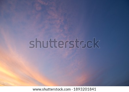 Natural color dramatic dawn or dusk sky with painterly yellow and blue clouds