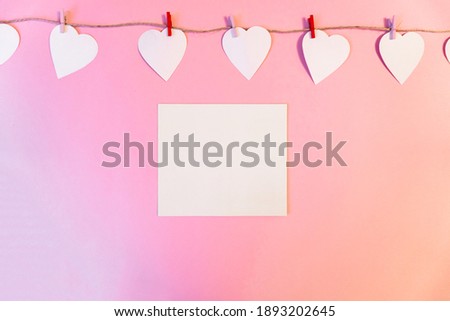 white hearts hanging on a linen thread on a pink  background. A 